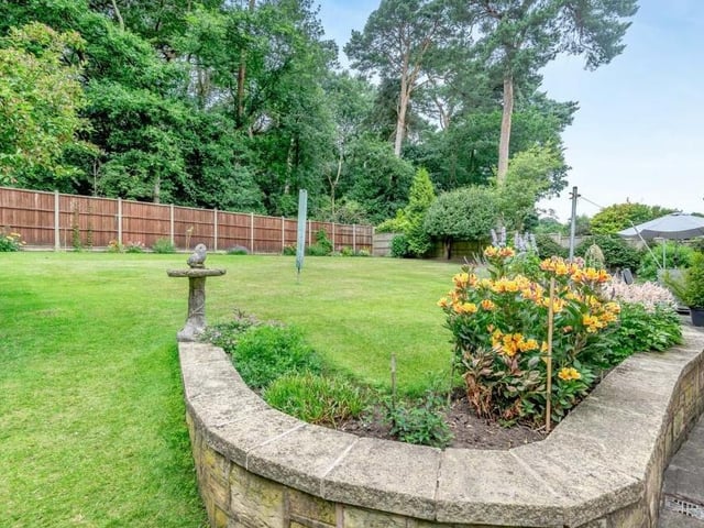 A path with a walled boundary wends its way round the side of the house to the back.