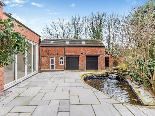 Let's take a look outside now, starting with this delightful Indian sandstone patio and garden pond with rockery and water feature at the back of the £625,000 property.