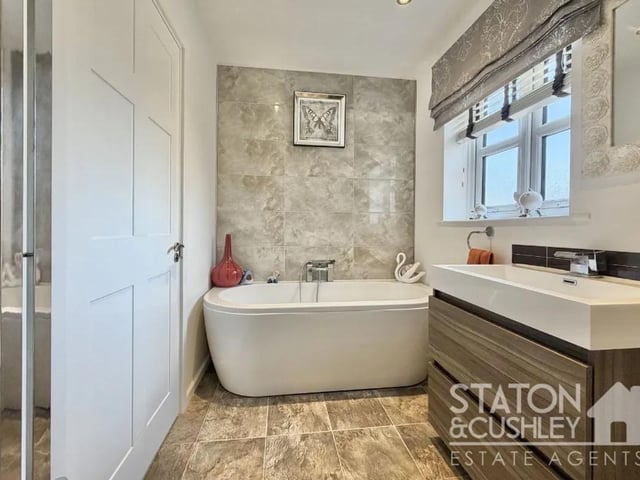 The luxurious family bathroom, beautifully appointed with a contemporary three-piece suite and high-quality fixtures and fittings, creating a spa-like retreat for relaxation.