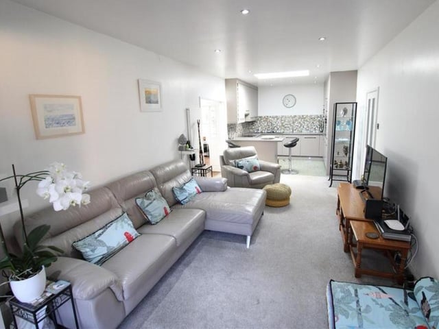 A shot of the lounge from the opposite end of the room. It shows how bright and spacious it is, with access to the kitchen at the far end.