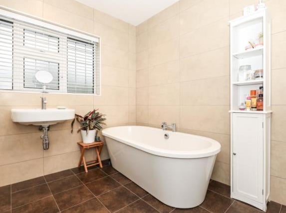 The family bathroom has a freestanding contemporary bath, shower cubicle and the combi-boiler concealed in a cupboard - with room for a tumble dryer.