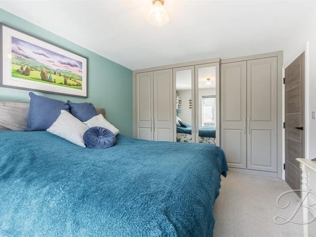 Bedroom two features a range of fitted wardrobes for storage.