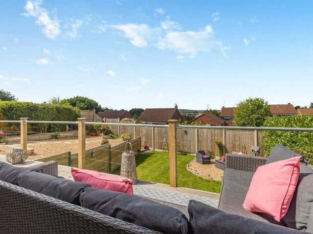 Before we have a look inside the bungalow, here is a sneak preview of that balcony-patio, with handrail, which overlooks the back garden and offers far-reaching views.
