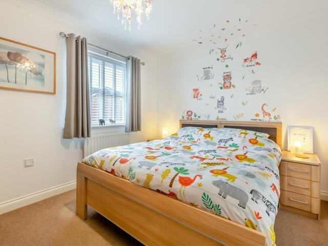 The third double bedroom on the first floor, which overlooks the rear garden, is a colourful affair. Fitted wardrobes with hanging rails and shelves add to its appeal.
