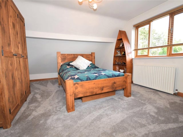 This double bedroom, which overlooks the side of the house, is a serene retreat, boasting ample wardrobe and storage space.