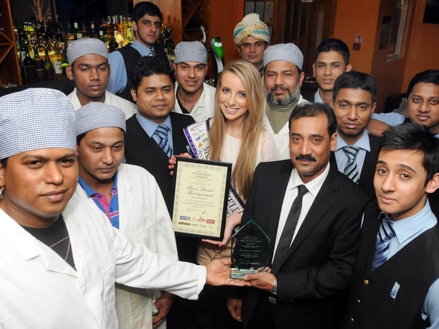 Miss Mansfield Chelsea Edgington with Mutahear Chowdury, owner of The Chand in Mansfield, pictured with the restaurant's latest award and staff members.       .