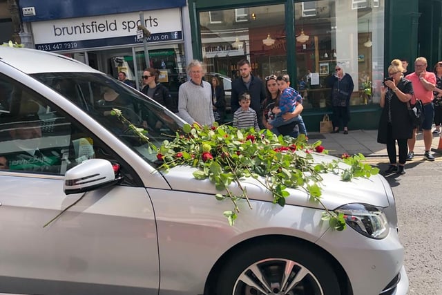Locals and business owners stood out to lay roses and say goodbye