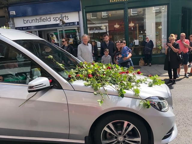 Locals and business owners stood out to lay roses and say goodbye