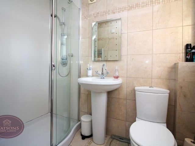 The primary bedroom has access to this en suite shower room. A three-piece suite is made up of a corner shower cubicle with mains-fed shower, pedestal sink unit and WC. There is also a chrome, heated towel-rail and ceiling spotlights.