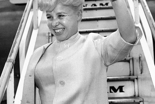 Barbara Windsor, waving farewell before leaving London Airport for her first ever visit to the United States in 1963.