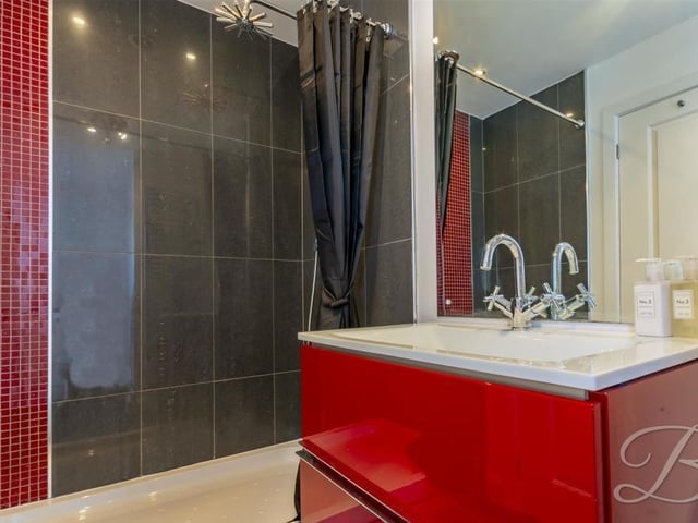 Here is another en suite bathroom at the property. A sparkling space, it comes with an enclosed shower, wash hand basin and low-flush WC.