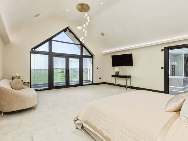 The stunning master bedroom has a floor to ceiling window with central doors giving access to the picturesque balcony.