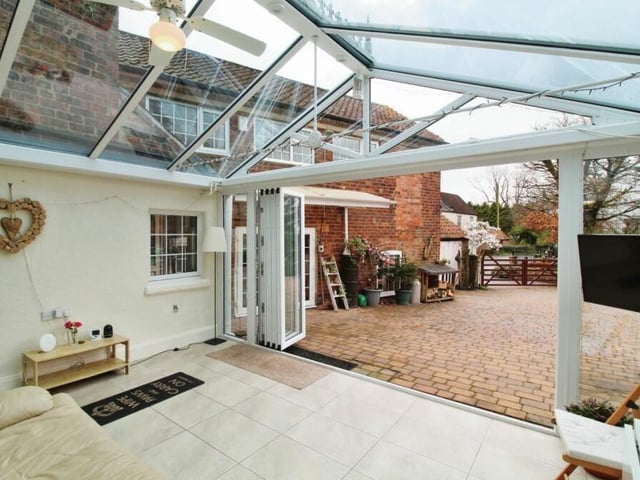 The conservatory is a sunny oasis perfect for lounging, reading, watching TV or enjoying meals, while surrounded by the beauty of outdoors. This photo shows the view from the large doors when open.