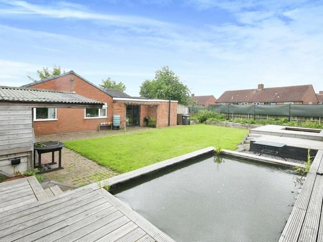 The pond, created as a home for koi carp, is set within a decking area in the garden.
