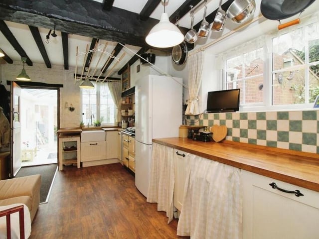 Other features of the retro kitchen include oak worktops, a pantry, ample storage space and free-standing appliances. The door shown here opens into the conservatory.