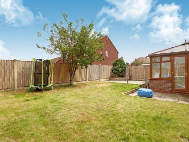 The enclosed back garden is mainly laid to lawn, with mature trees. There are also two paved patio areas, accessed from the conservatory.
