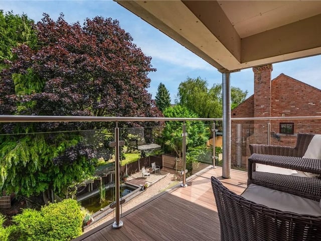 The master bedroom features a door leading to a private veranda with stunning views over the garden.