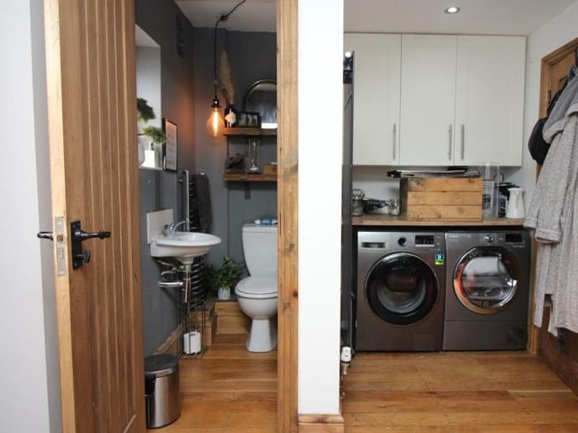 The boot room, with its exposed wooden flooring and ceiling spotlights, also houses a downstairs WC and utilities. There is space and plumbing for a washing machine and tumble dryer.