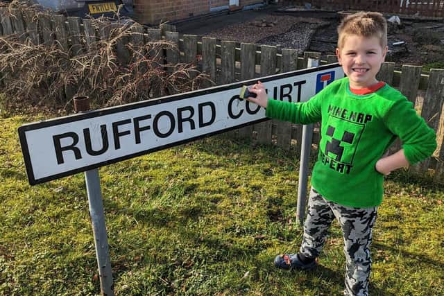 Dylan Cheney, 6, with the gleaming 'Rufford Court' sign. The youngster took it upon himself to clean the sign after noticing it was covered in dirt.