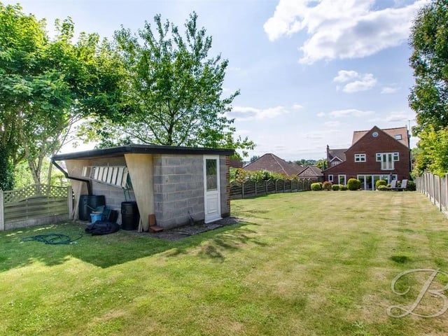 The back garden features a well-maintained lawn bordered by mature planting and fencing for added privacy. Added brick built garage at the top of the garden.