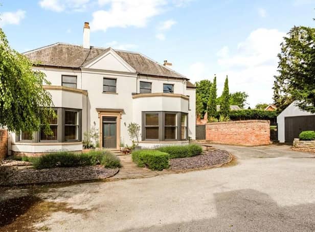 This magnificent Georgian family home is on the market at a guide price of £1,175,000. It has been superbly restored and renovated by the current owners. As you can see, the frontage features mature flowerbeds and shrubs with small trees and a paved pathway, all partially enclosed by brick walling.