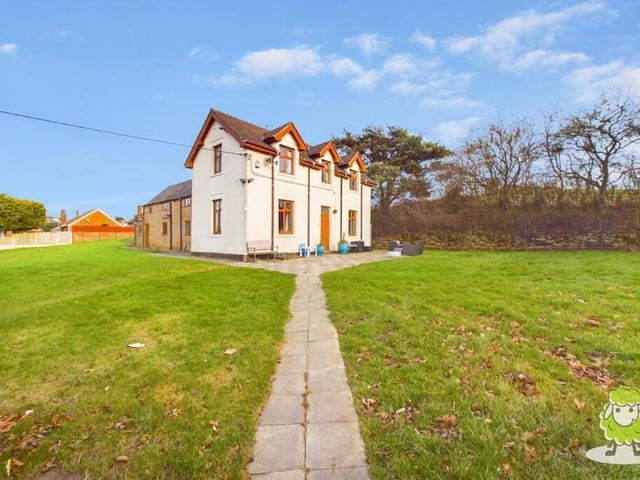Time to step outside now, and this photo captures the farmhouse in full daylight, surrounded by well-maintained gardens and woodland.