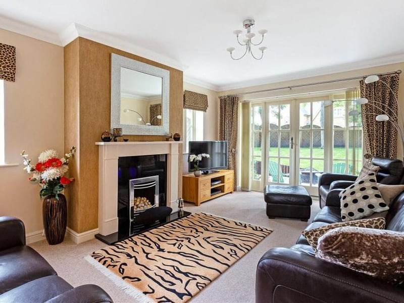 The sitting room, nestled in a rear corner of the property, is a lovely, bright space. Its focal point is a fireplace with granite hearth, inset gas fire and stone surround and mantelpiece. Large French doors lead out to the garden.