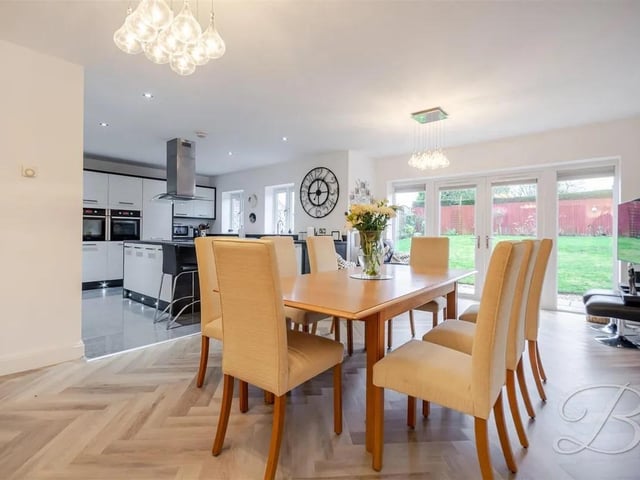 Herringbone flooring flows through to the dining room, offering ample space for your desired dining furniture, with patio doors to the rear.