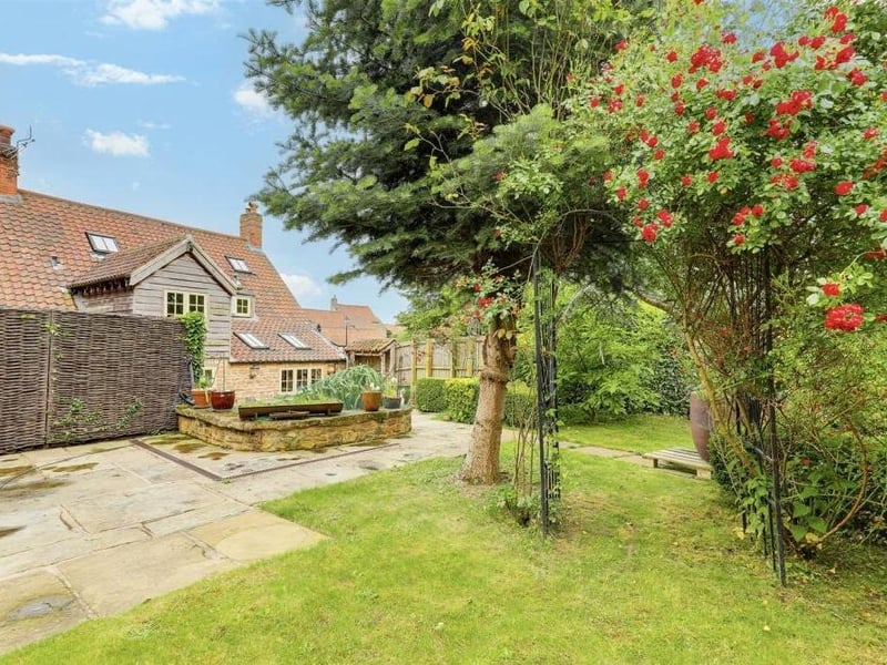 The back garden is that of a typically tranquil countryside retreat, offering a lush lawn, and a variety of established trees, plants and shrubs