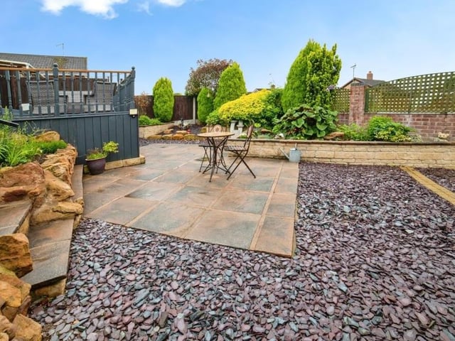 Let's step outside now to take a look at the expertly landscaped garden at the back. It is on two levels, with this being the lower area, containing a patio, a gravelled section and a wide range of borders and shrubs.