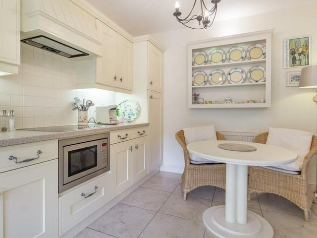 Another look at the kitchen, which has space for a breakfast table and is blessed with contemporary cabinets and cupboards with inset spotlights, plus base units and drawers with work surfaces above. It also features an inset one-and-a-half bowl sink with drainer and mixer tap, a wine rack and marble tiled floor.