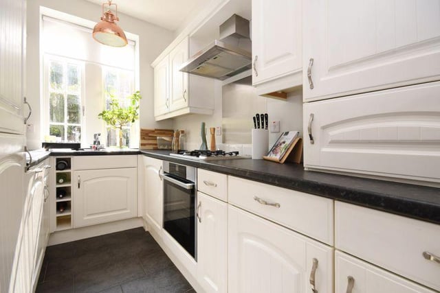 The kitchen has a range of white-fronted fitted units - included with the sale is an integrated oven, hob, extractor, dishwasher, washer dryer, fridge, and freezer.