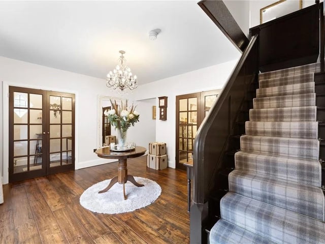 Traditional door to the front aspect, double doors leading into the hallway, doors leading to the dining room, lounge, cloakroom, snug and kitchen diner, two double glazed bay windows to the front aspect, wooden flooring and stairs leading to the first floor.