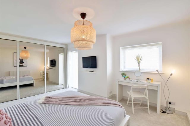 A large second bedroom comes with fitted wardrobes and two double-glazed windows providing views over the beach and sea.