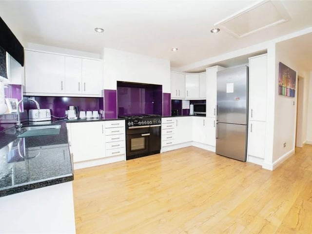 The sleek laminate flooring provides a contemporary look whilst ensuring durability and easy maintenance. Spotlights embedded in the ceiling enhance the modern appeal. Integral appliances are built into the cabinetry and maintain a streamlined aesthetic.