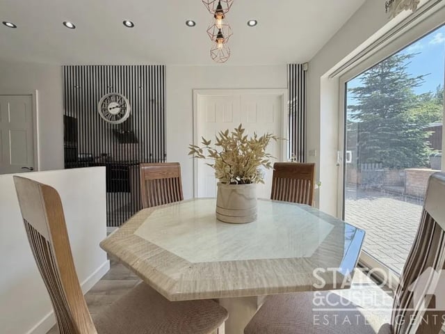 The kitchen features ample space for dining and is complemented by elegant sliding doors, creating a seamless connection between the indoor and outdoor living spaces.