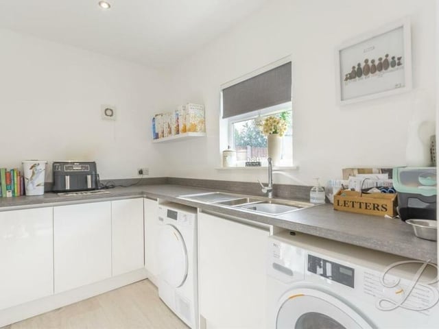 Close to the kitchen is this useful utility room, which has space and plumbing for a washing machine and tumble dryer. A work surface, sleek cabinets and units and an inset sink and drainer are handy additions.