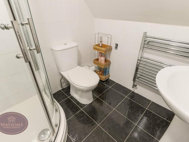The bedrooms on the second floor are served by this shower room, which is a three-piece suite in white, consisting of shower cubicle with electric shower, pedestal sink unit and WC -- plus chrome, heated towel-rail and extractor fan.