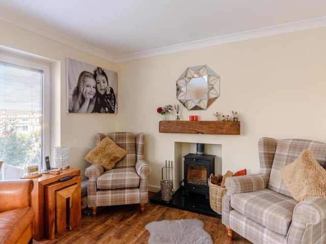This image shows the other side of the dining room, with its characterful log-burner, granite hearth and inset wood mantle above.