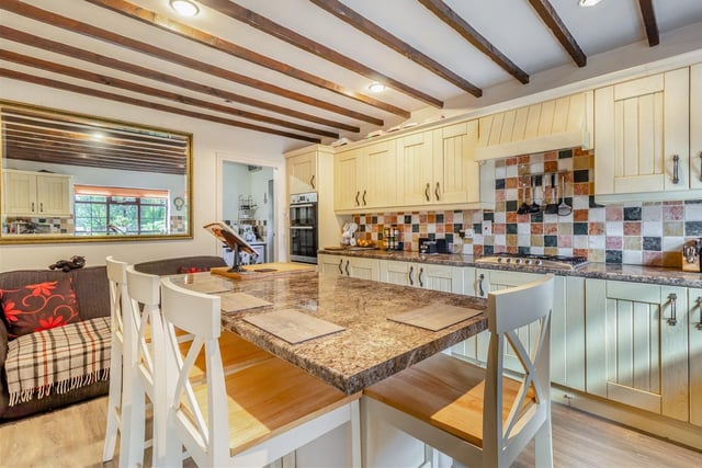 A host of integrated appliances within the kitchen include a double oven, a five-ring stainless steel gas hob and extractor hood above, dishwasher and fridge. A vinyl floor and ceiling spotlights are other features.