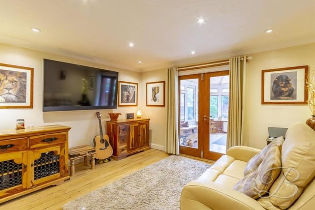 The snug, or sitting room, is an additional spot to unwind at the £650,000 house. With a feature fireplace, downlights and coving, it also has French doors leading into the conservatory.