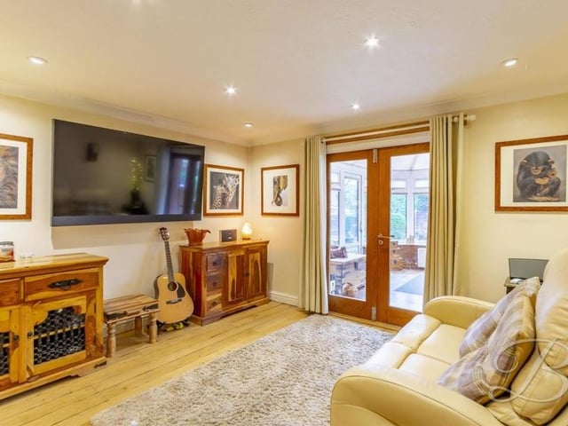 The snug, or sitting room, is an additional spot to unwind at the £650,000 house. With a feature fireplace, downlights and coving, it also has French doors leading into the conservatory.