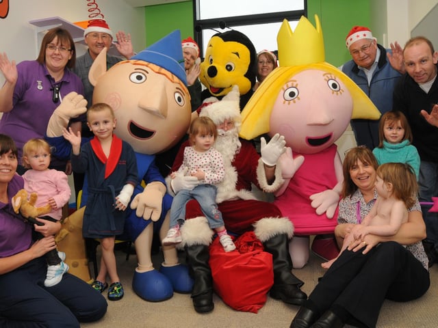 Mansfield Panto characters pictured with Father Christmas and Mansfield Christmas lights supporters during their visit to the Children's Ward at King's Mill Hospital.