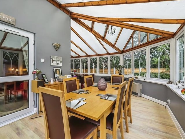 The dining room opens seamlessly into this huge conservatory, which in itself could be set up as a dining space. In fact, so big is it that there is space for a full-sized pool table, which you can just make out in the background of this image. Large windows offer superb views of the garden, which can be accessed via a patio door. Wall lights, a laminated floor and an energy-saving gas heater are further assets.
