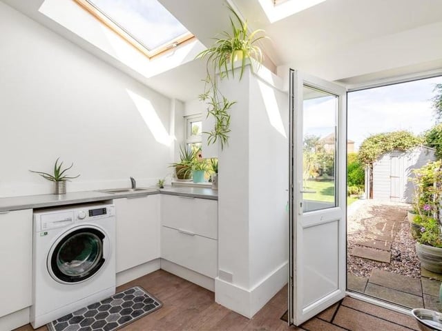 The property's utility room boasts plumbing for a washing machine and space for an additional fridge or freezer. It also has high-gloss cabinets, a stainless steel sink, two Velux roof windows and a door leading to the back garden.