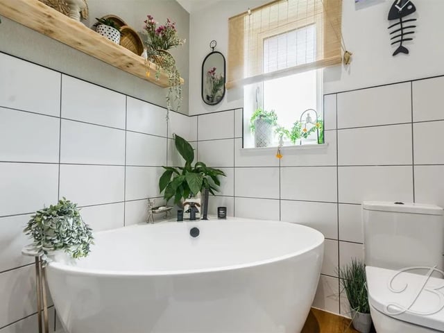 Complete with a three piece suite comprising of a free standing corner bath, low flush WC, vanity sink with mixer tap, half tiled walls and window to rear elevation. There is the added luxury of having a built in mirror TV to enjoy.