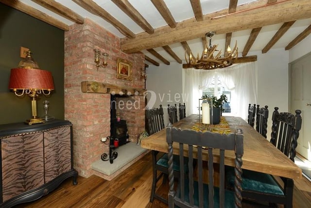 Maintaining the rustic feel throughout the cottage, this stunning dining room is perfect for entertaining. Traditional features include oak beams, and another open fireplace with exposed brickwork and a log burner. The double-glazed window faces the front of the property.