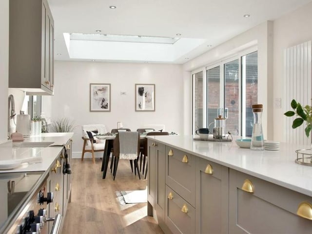The kitchen features a range of modern shaker-style cabinets, comprising wall cupboards, base units and drawers, complemented by quartz worktops. There is an integrated fridge/freezer and dishwasher.