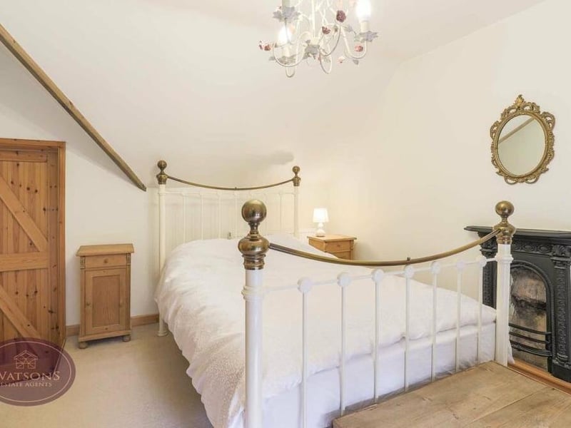 Another of the four bedrooms at the former pub. This one is cute and quaint, with another feature fireplace.