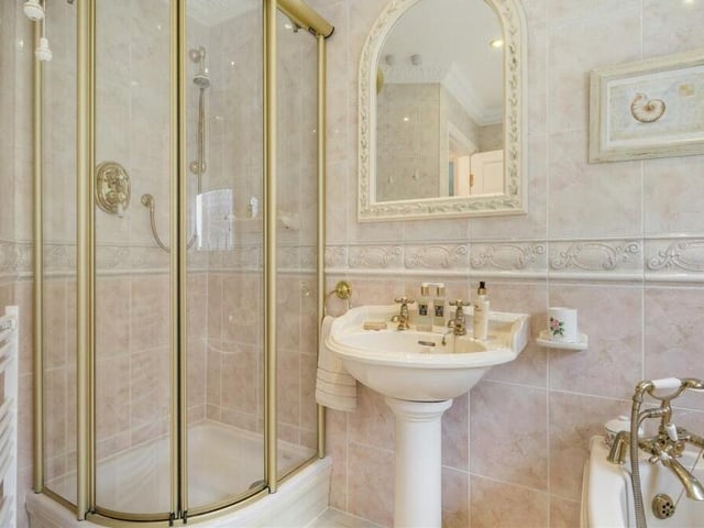 The main bathroom also features this tiled shower enclosure. The floor and walls are also tiled, and there are seven ceiling spotlights, plus two heated towel-rails.